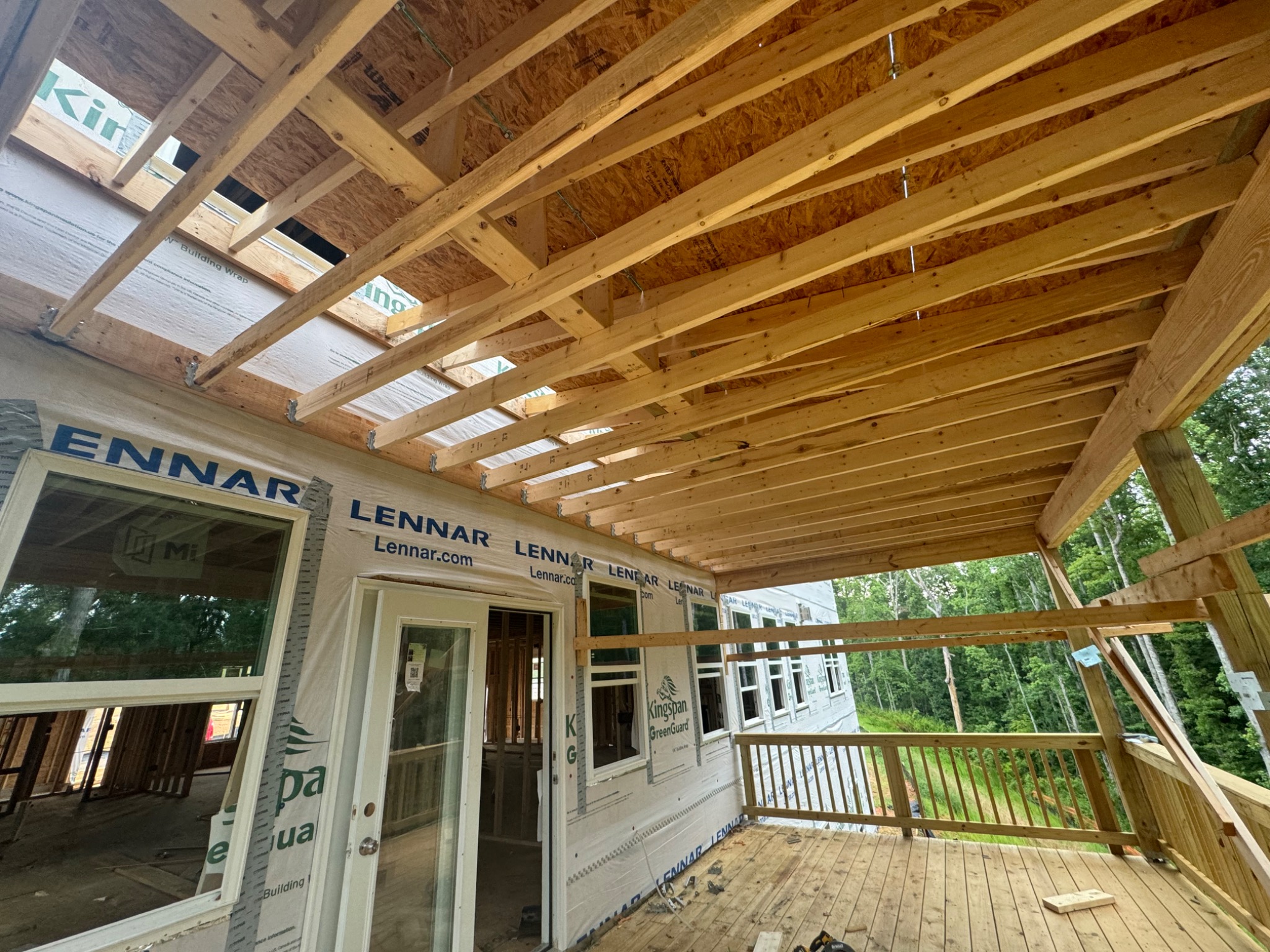 Installed windows and door beneath a framed covered porch
