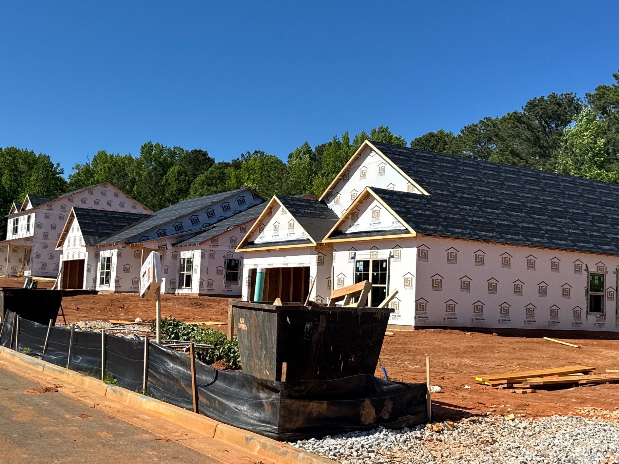 Homes under construction with exterior wrap and installed windows