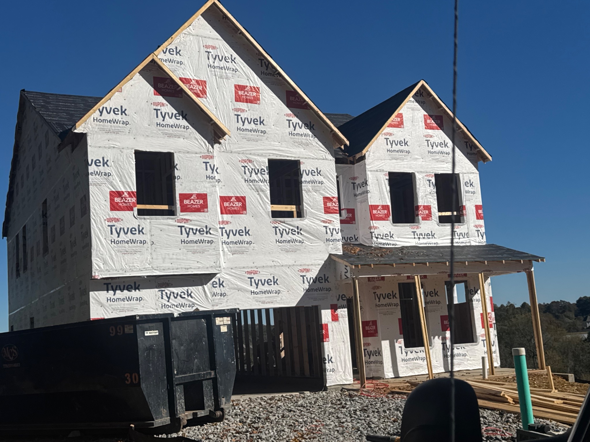 Two-story home covered in house wrap with window openings